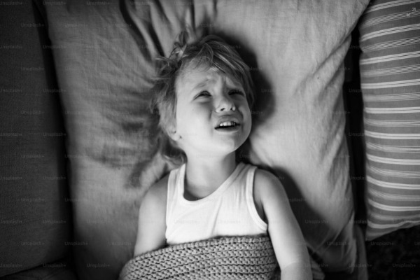 Kind liegt mit offenen Augen im Bett – Symbolbild für Schlafprobleme bei Kindern und die Situation, wenn ein Kind nicht schlafen will